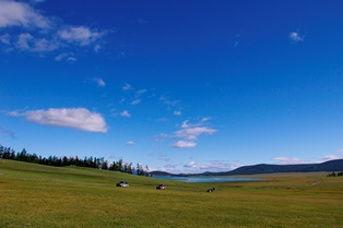 広大な青い空と湖、緑の草原
